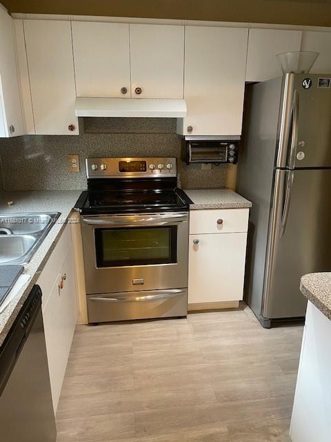 a kitchen with granite countertop a stove and a refrigerator