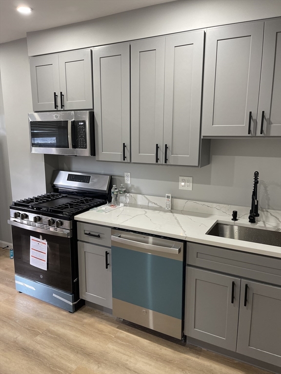 a kitchen with stainless steel appliances granite countertop a sink and a stove