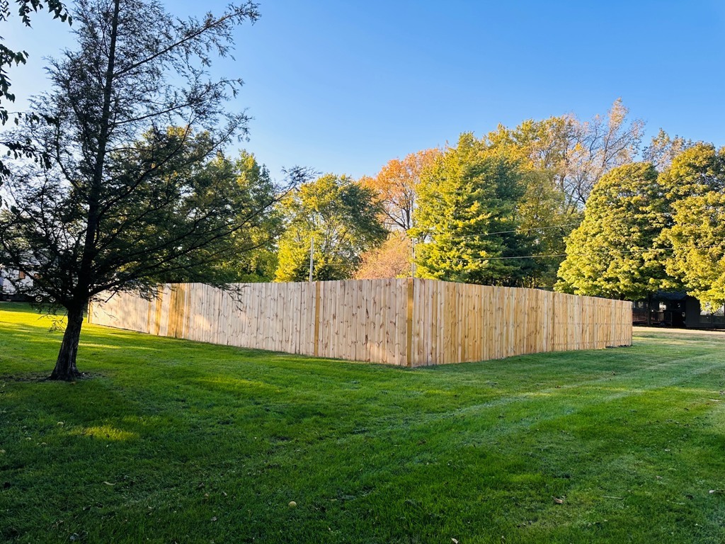 a view of yard with swimming pool and trees in the background