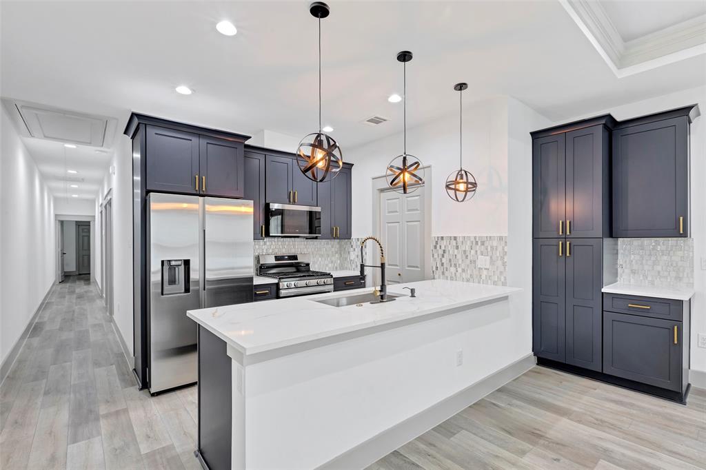 a kitchen with a sink stainless steel appliances and counter space