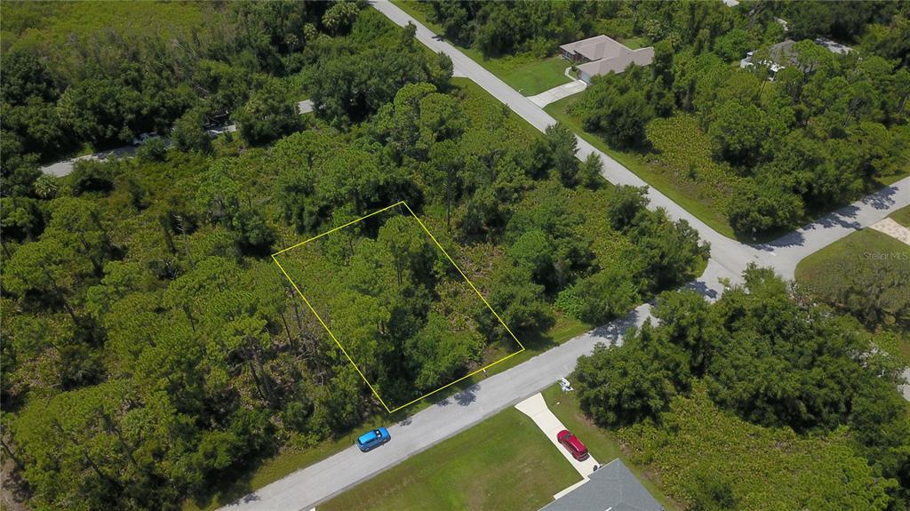 an aerial view of residential house with outdoor space and trees all around