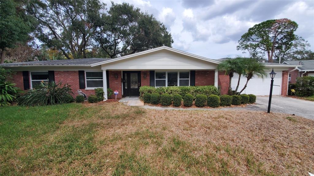 a front view of a house with a yard and potted plants