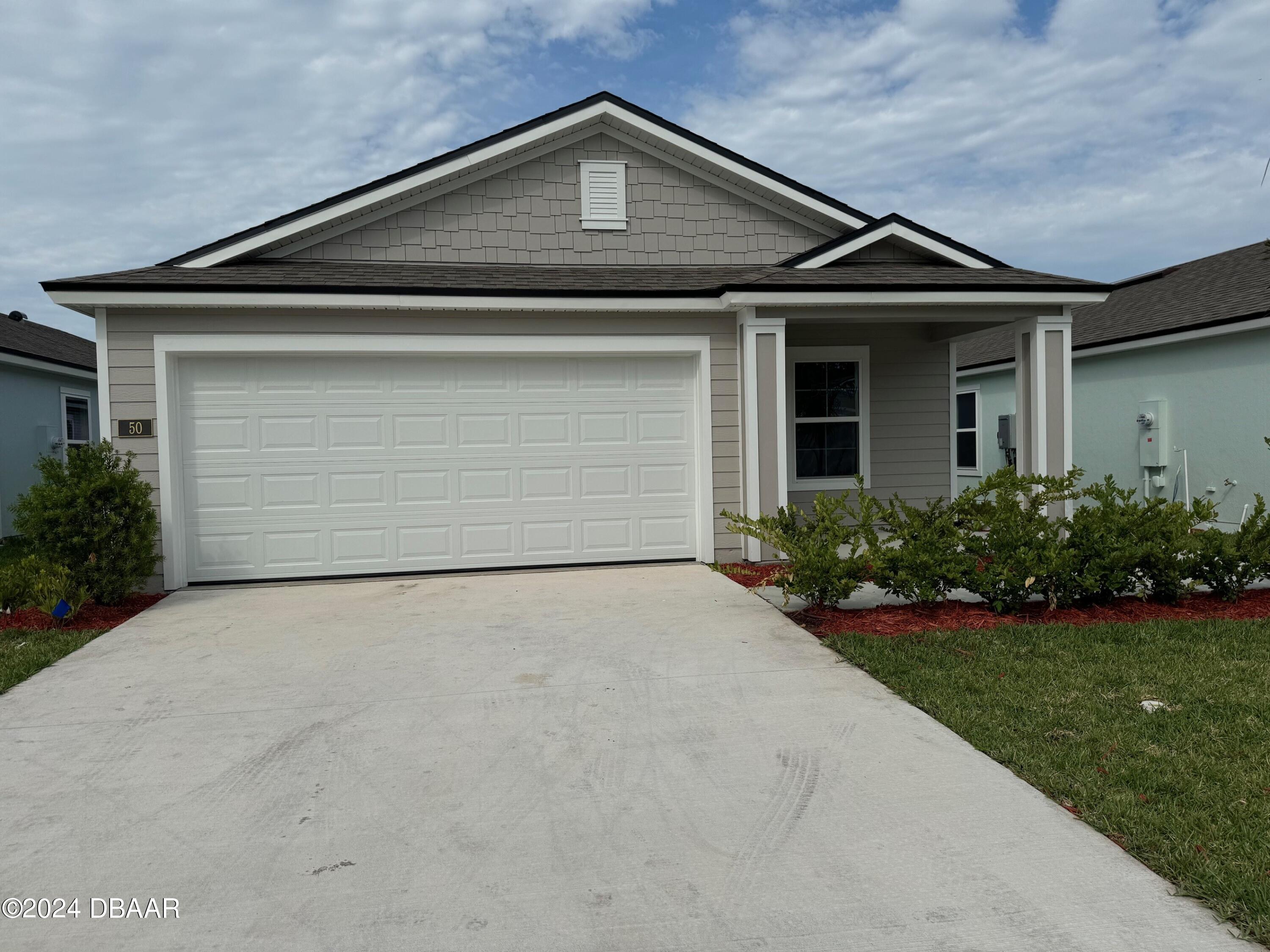 a front view of a house with a yard and garage