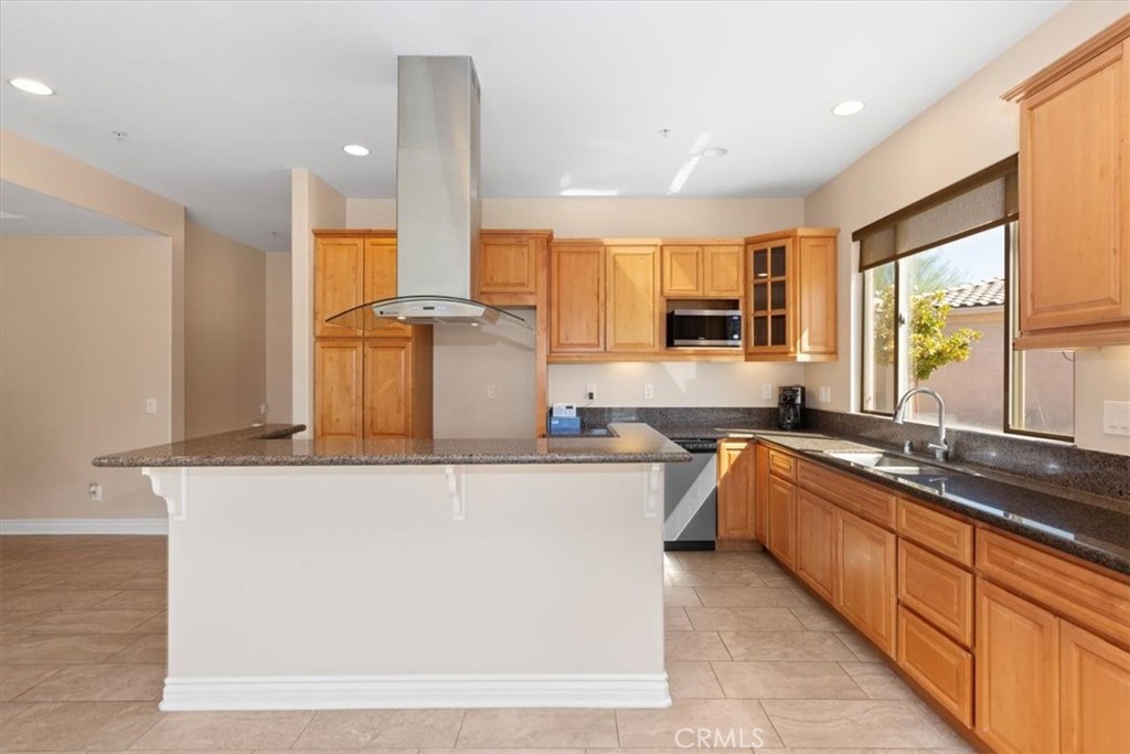 a kitchen with stainless steel appliances granite countertop a sink and a refrigerator