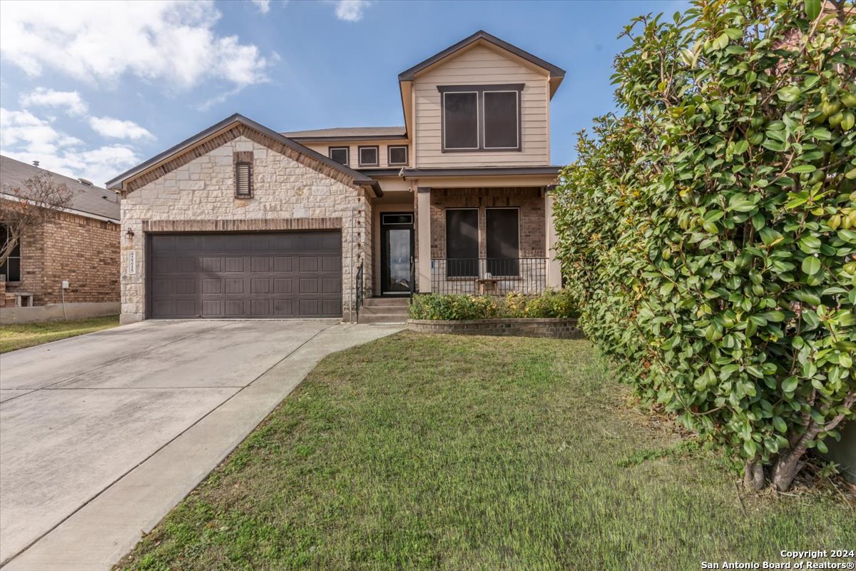 a front view of a house with yard and garage