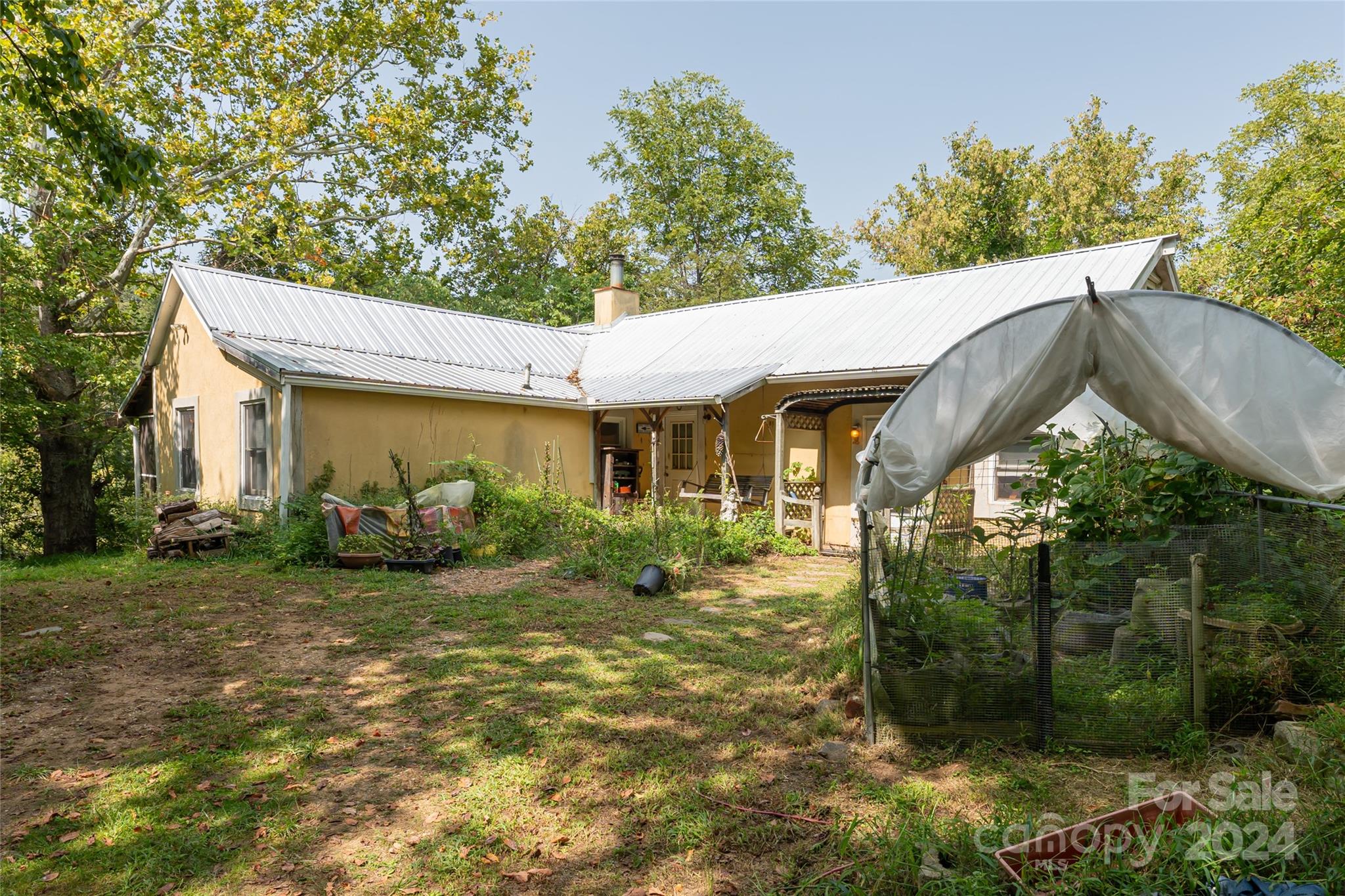 a view of a house with backyard garden and tree