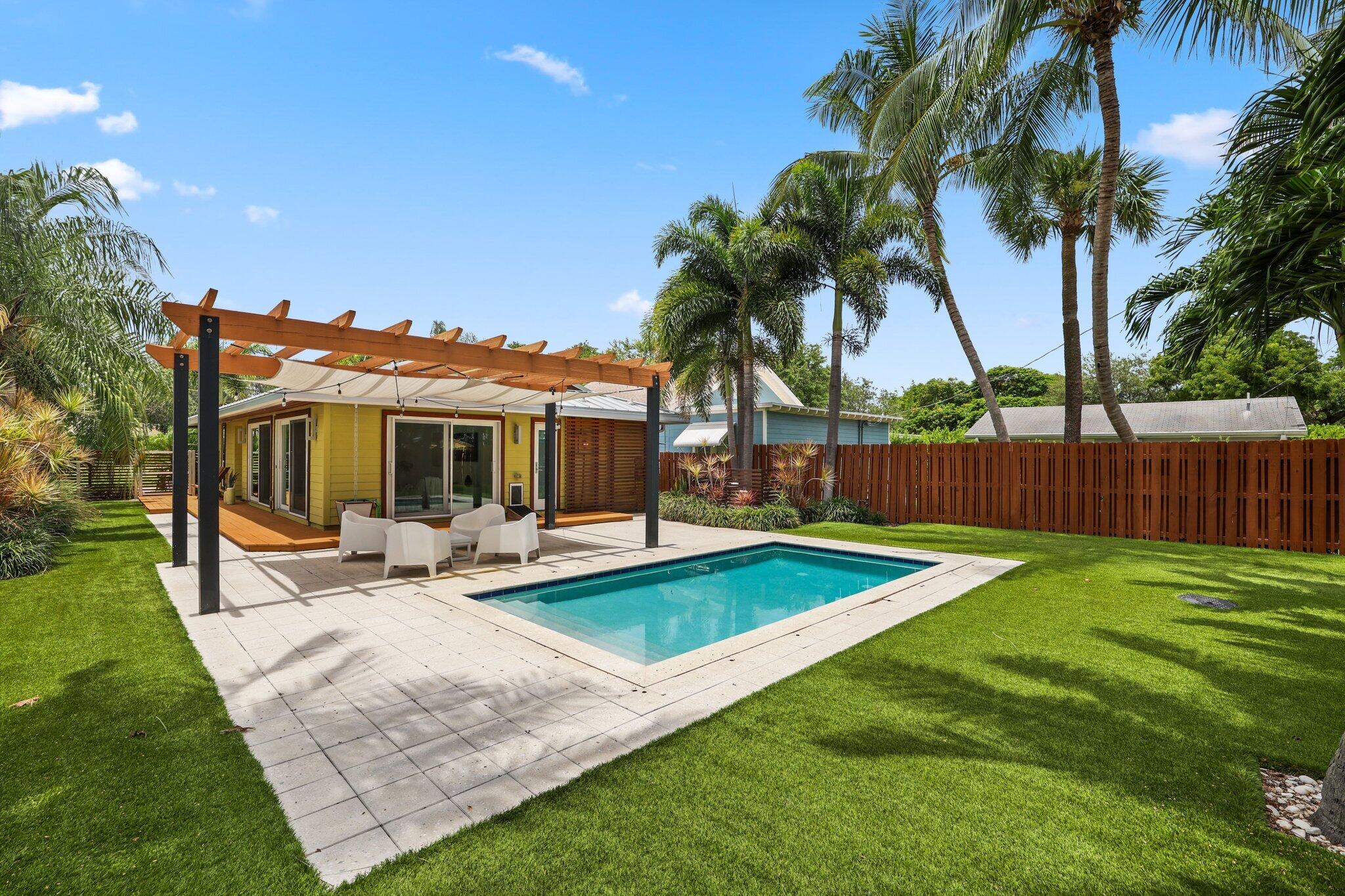 a view of a house with swimming pool and sitting area