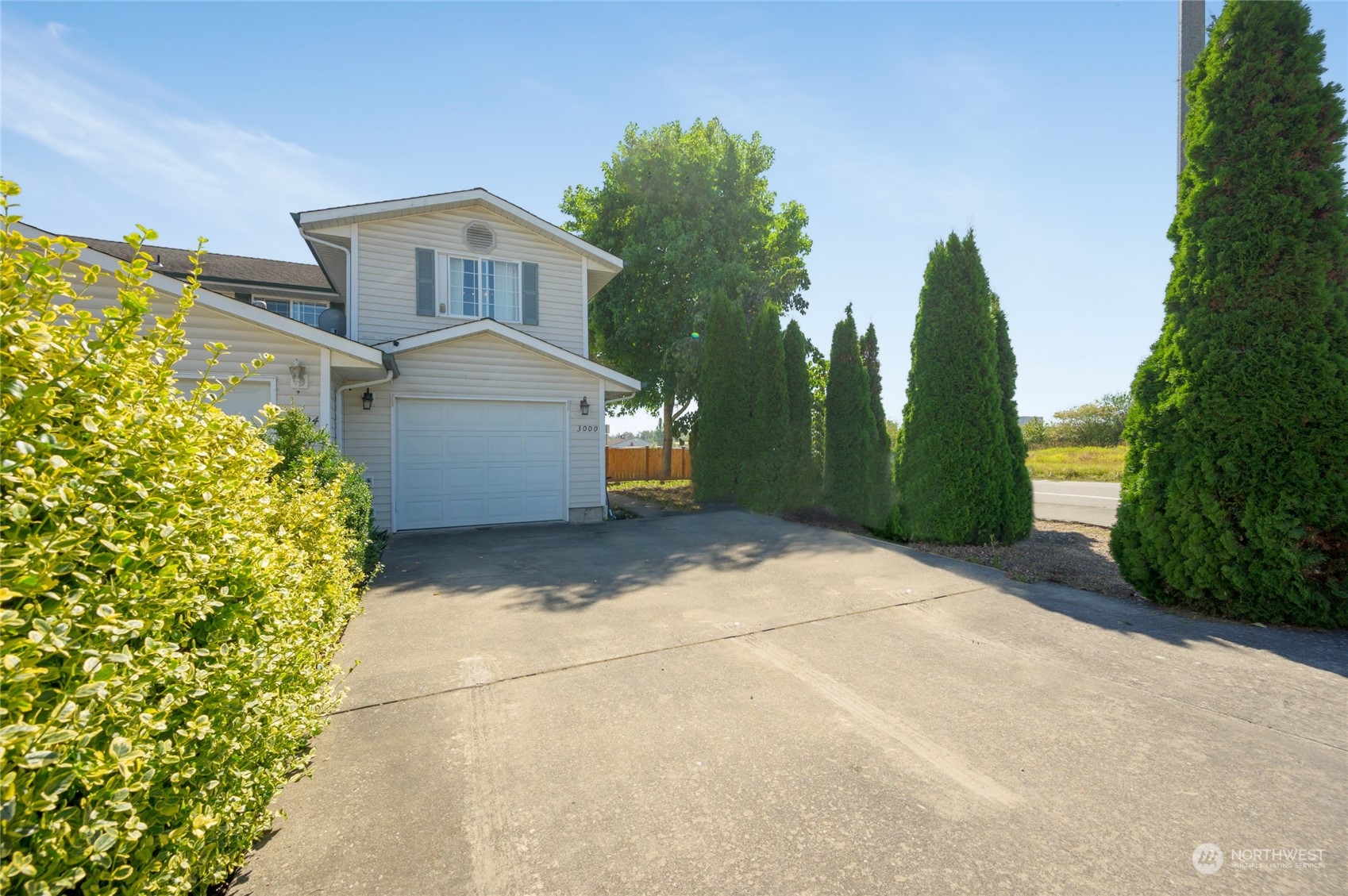 a front view of a house with a yard and trees