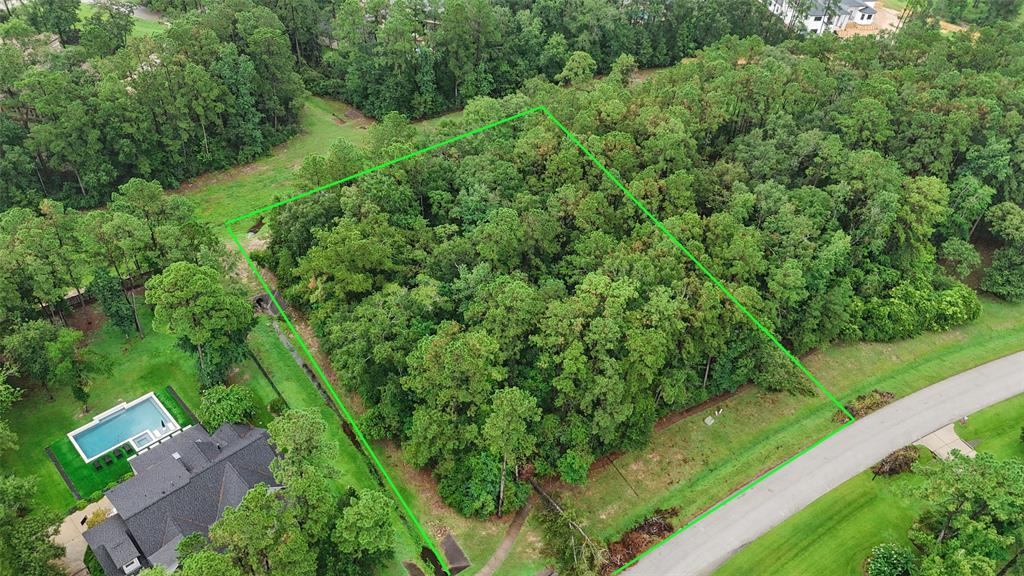 an aerial view of residential house with outdoor space and trees all around