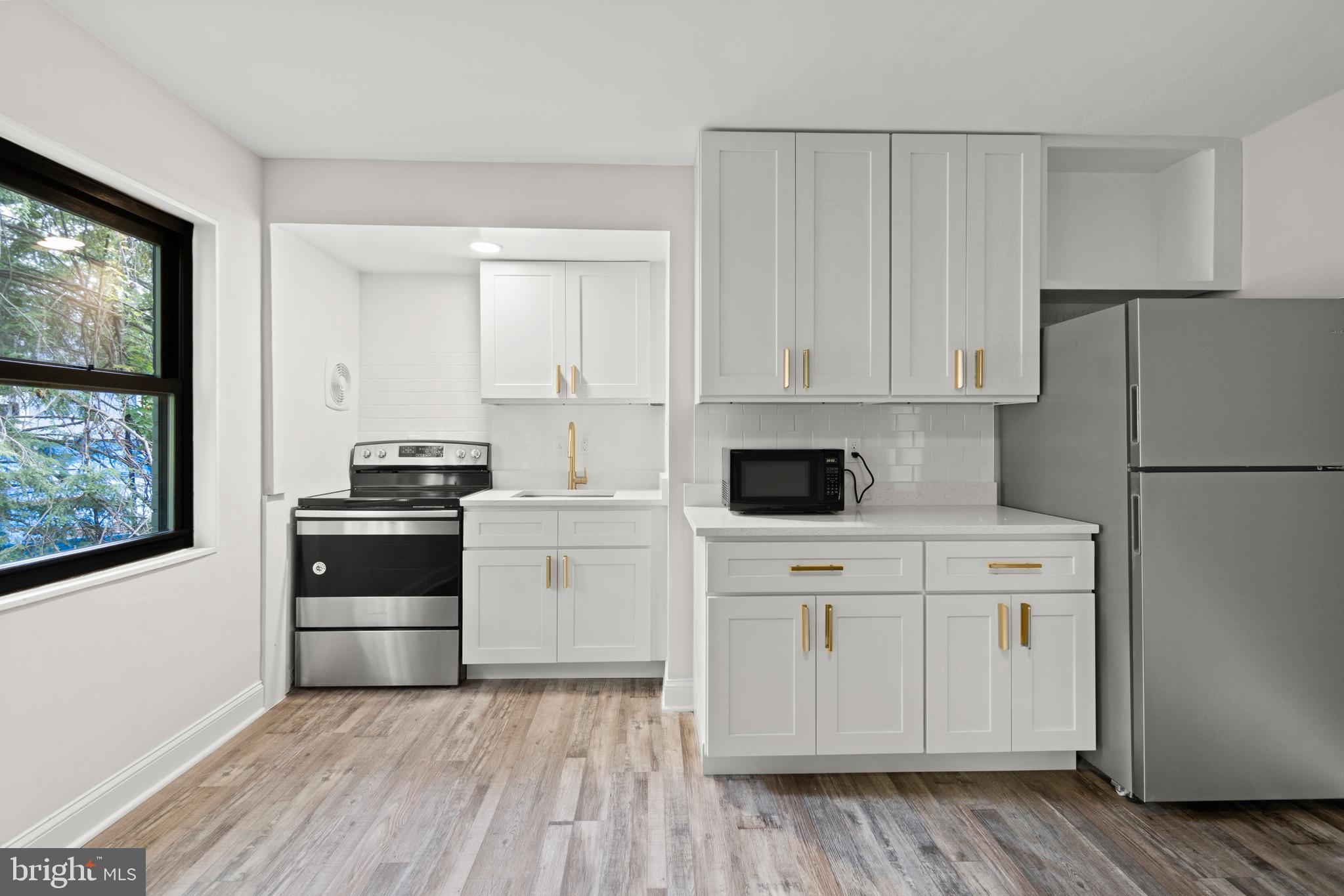 a kitchen with a refrigerator stove and white cabinets