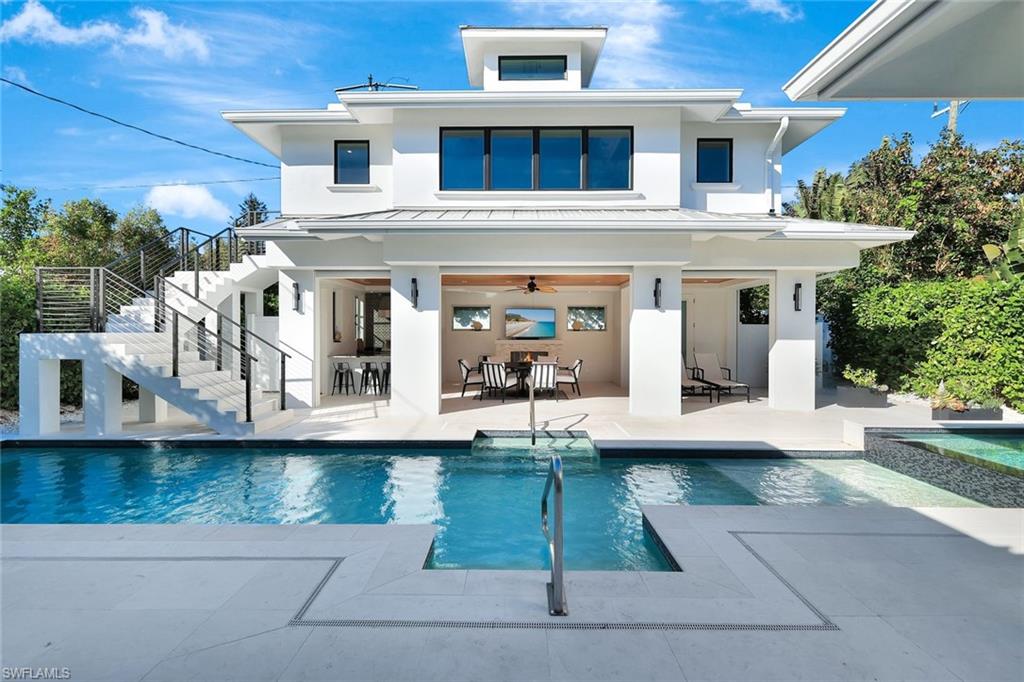 Back of house featuring ceiling fan, an outdoor bar, and a patio