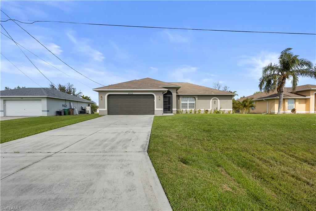 Ranch-style home with a front yard and a garage