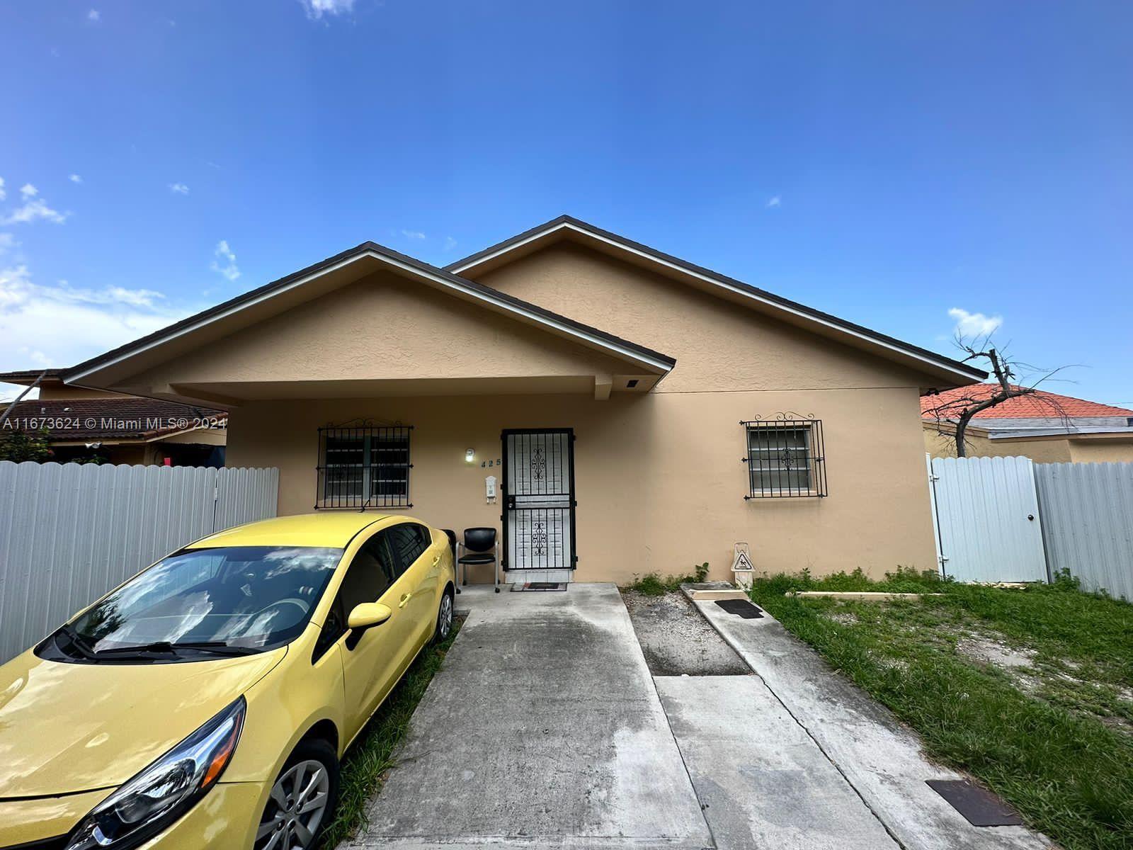 a front view of house with yard and car parked