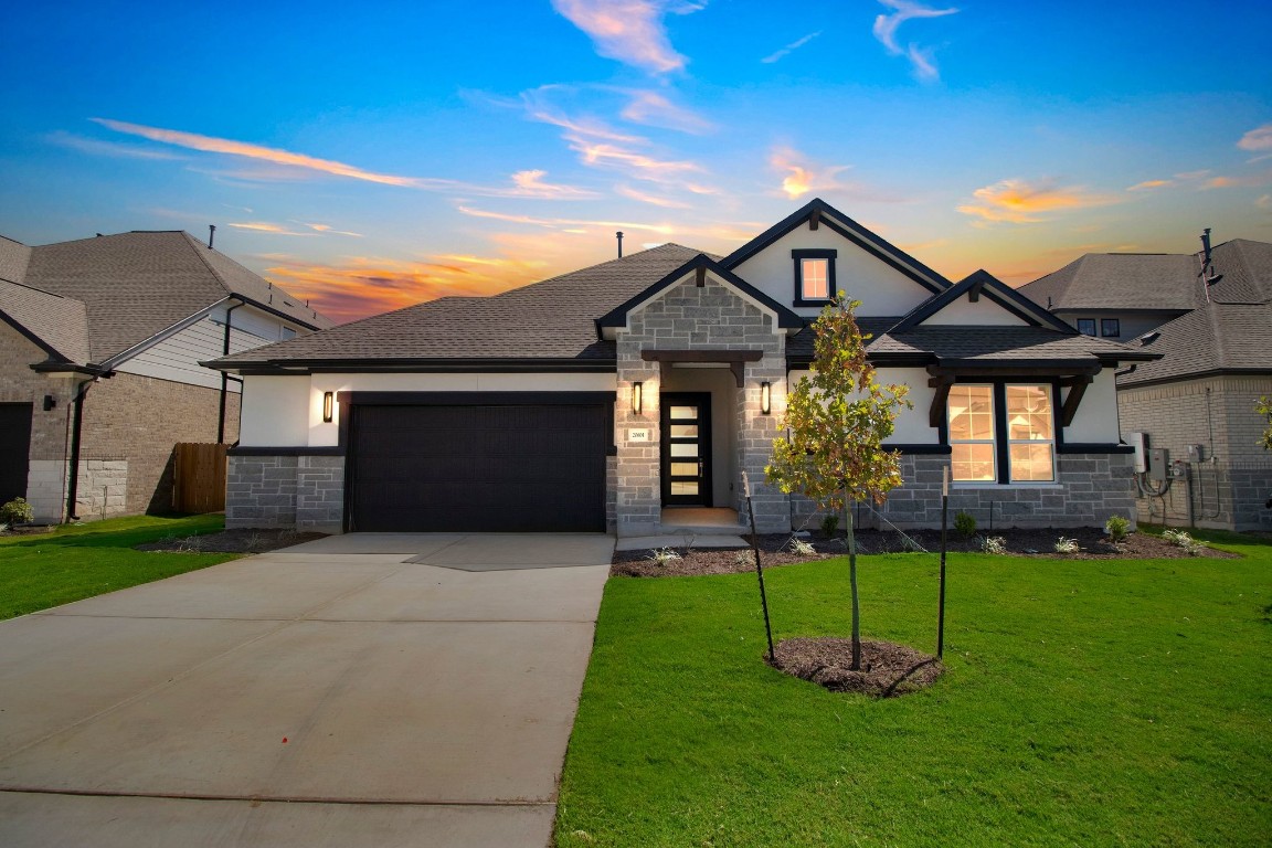 a front view of a house with a yard and trees