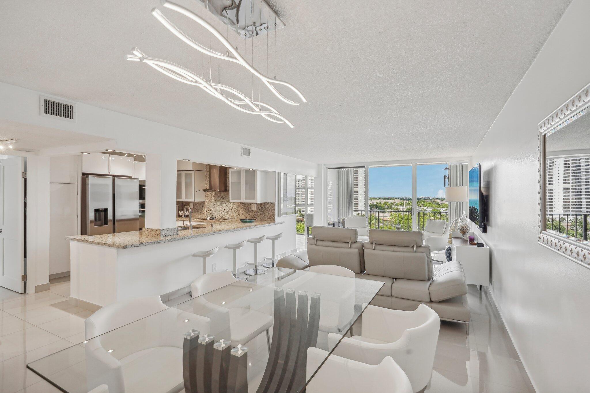 a large living room with stainless steel appliances kitchen island granite countertop furniture and a living room view