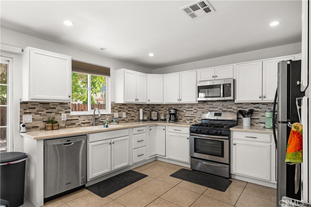 Kitchen with granite counter tops, tile backsplash and flooring.  Built-in microwave and a dishwasher for convenience.