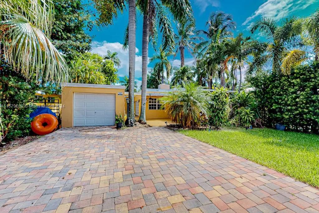 a backyard of a house with potted plants and palm trees