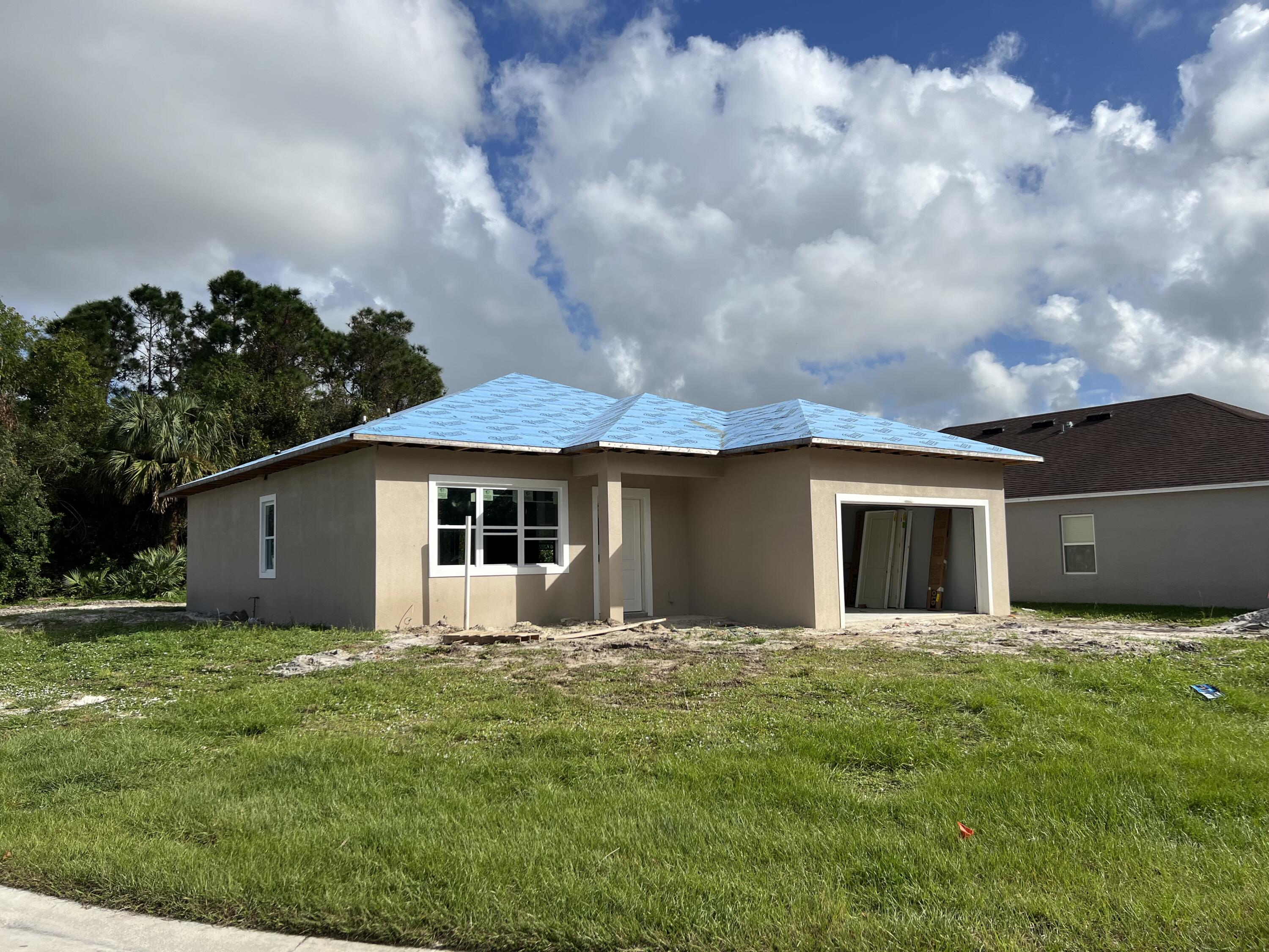 a front view of house with yard and trees in the background