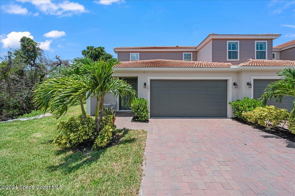 a front view of a house with a yard and garage