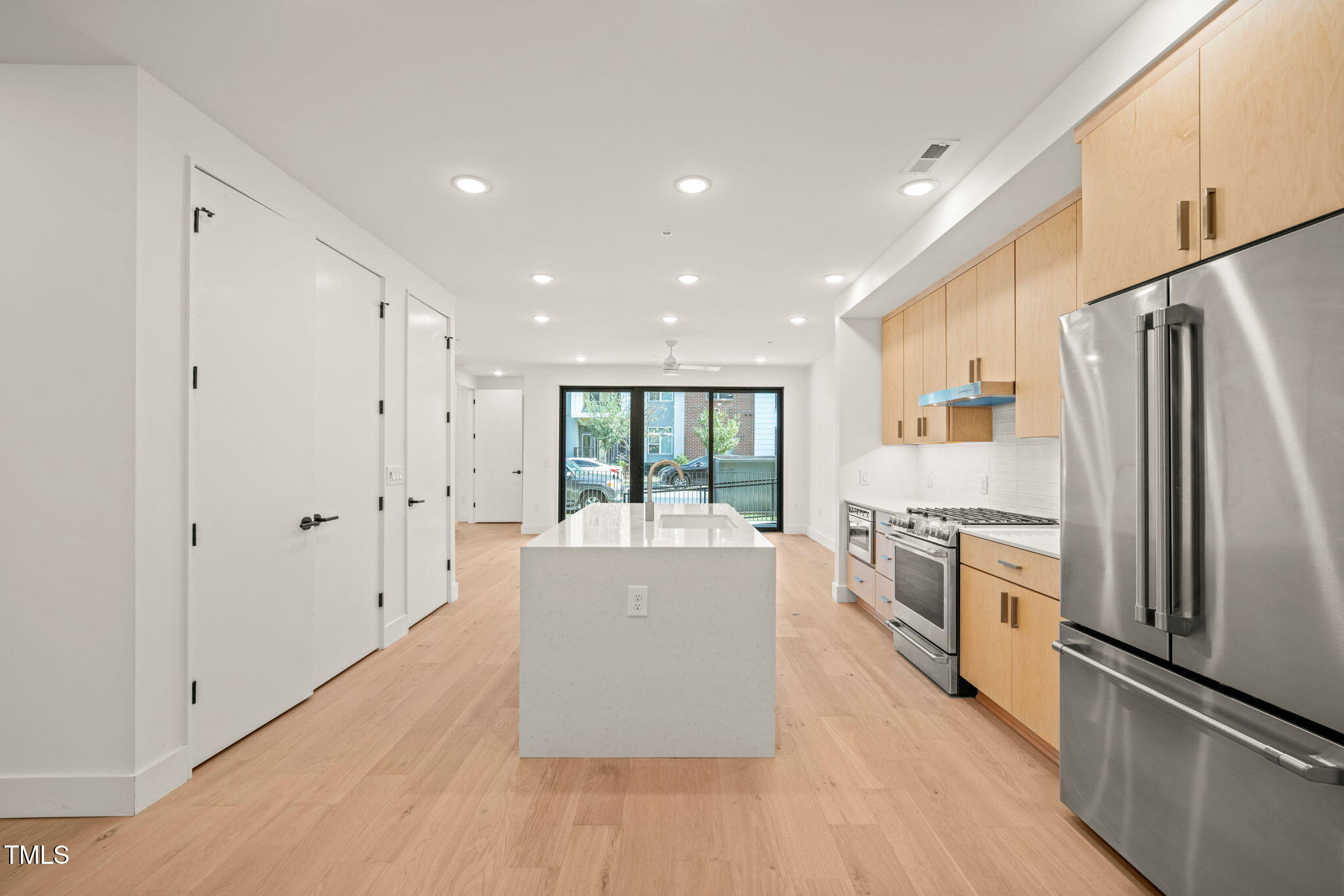 a large kitchen with a large window a refrigerator and a stove