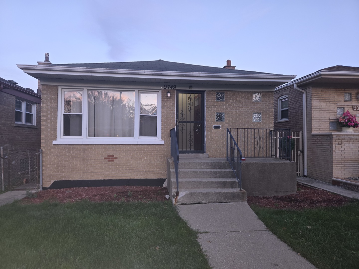 a view of a house with a small yard and wooden floor and fence