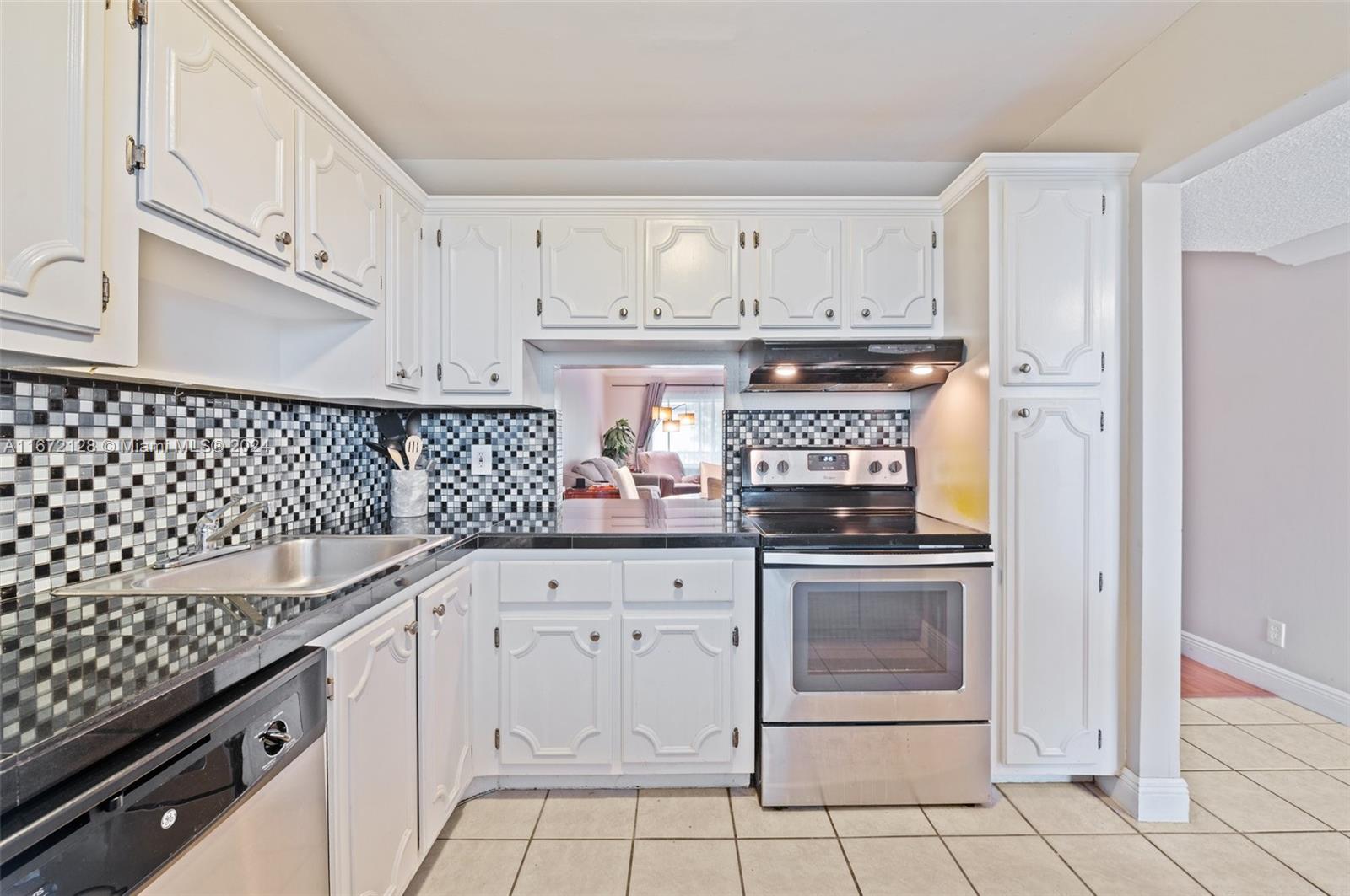 a kitchen with white cabinets and appliances