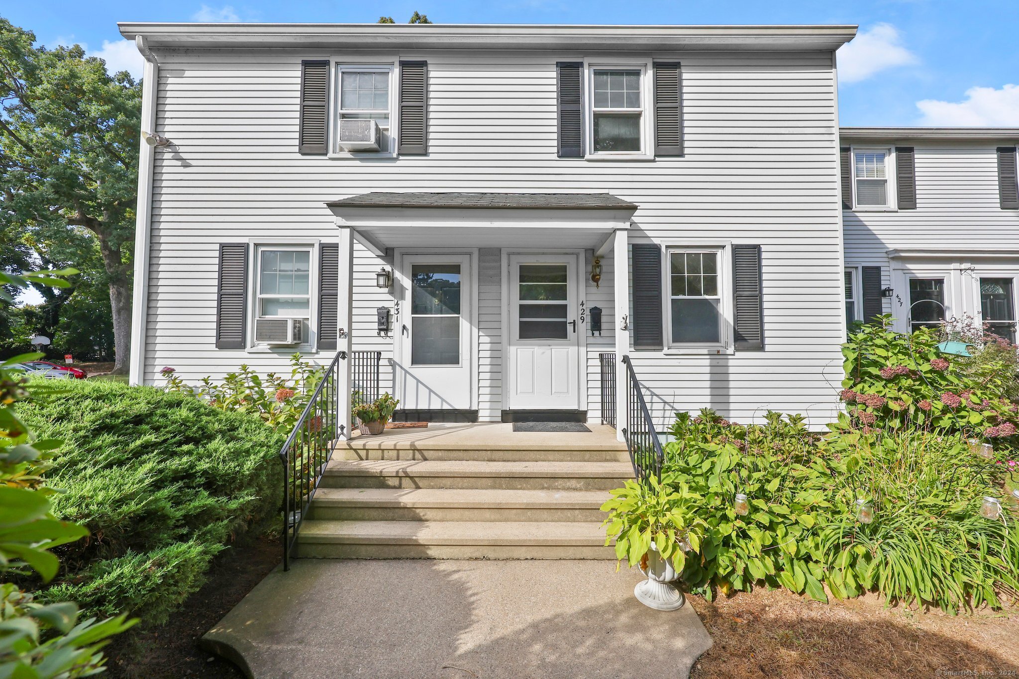 a front view of a house with plants