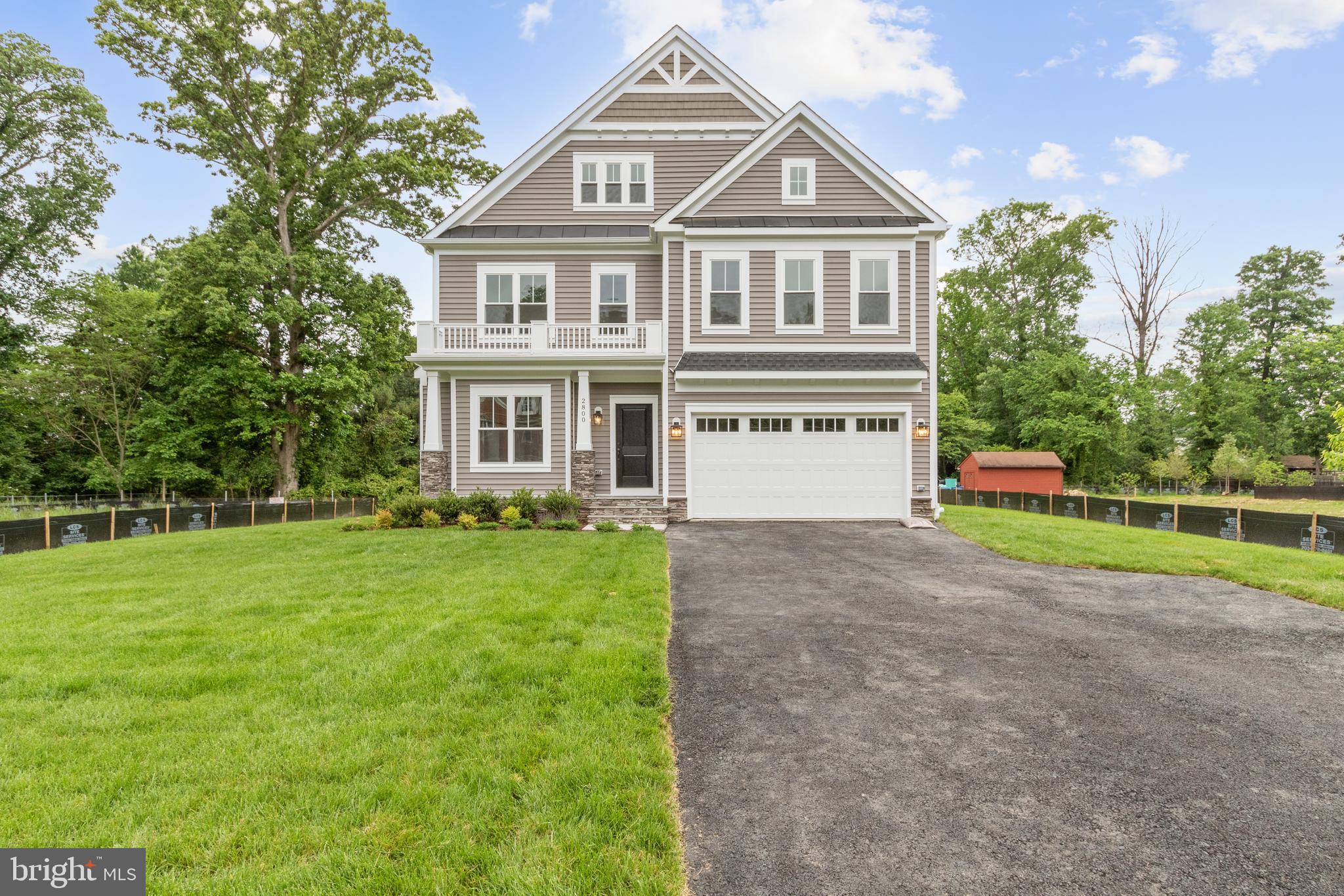 a front view of a house with a yard and trees