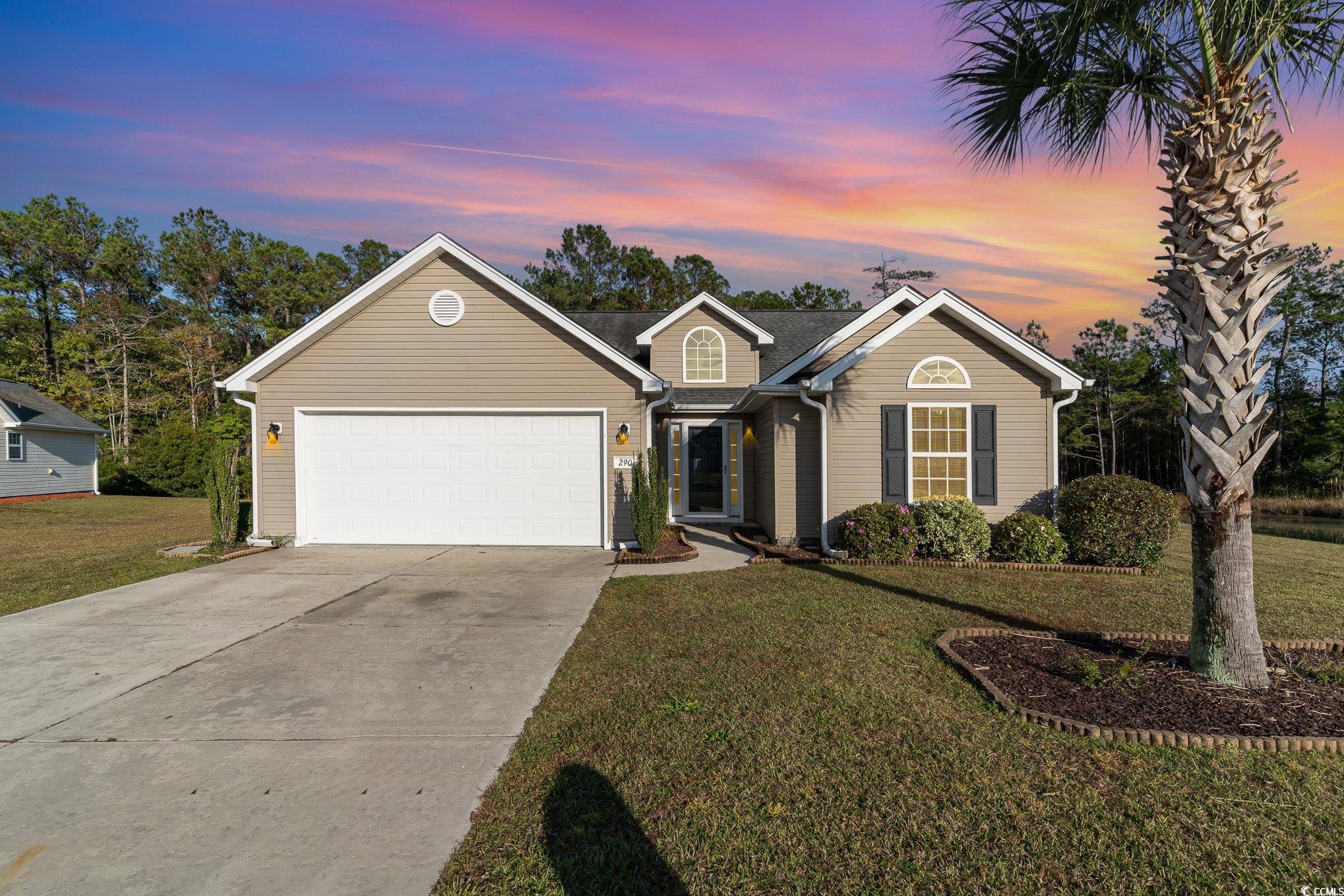 View of front of home featuring a garage and a yar