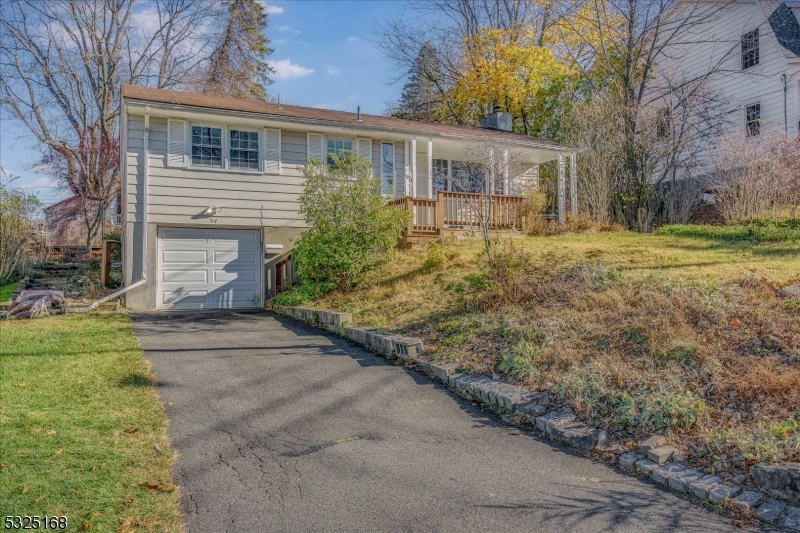 a front view of house with yard and trees around