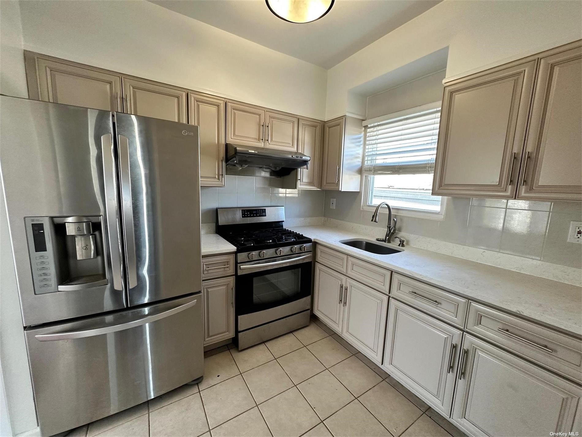 a kitchen with stainless steel appliances a refrigerator sink and microwave