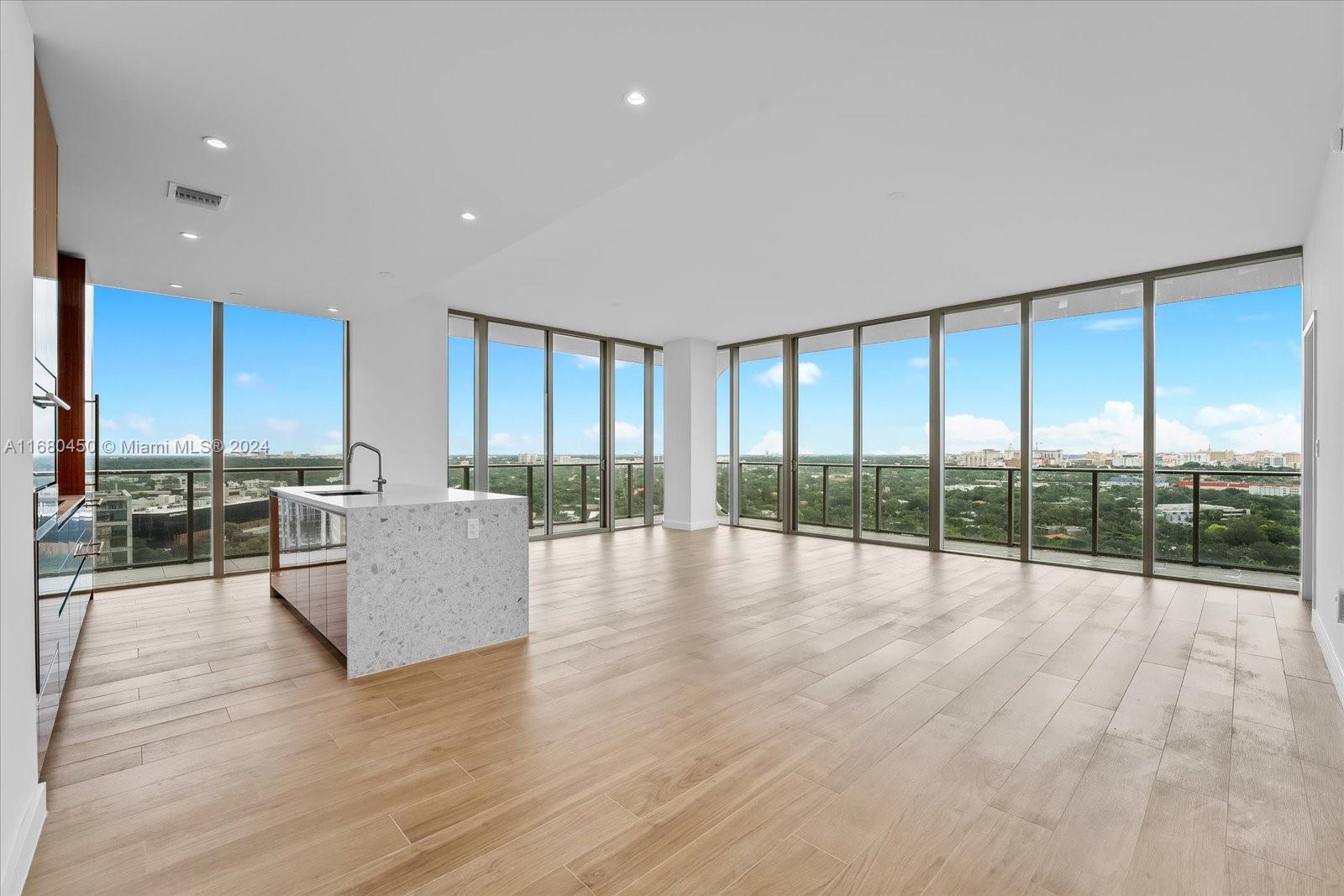 a view of empty room with wooden floor and floor to ceiling window