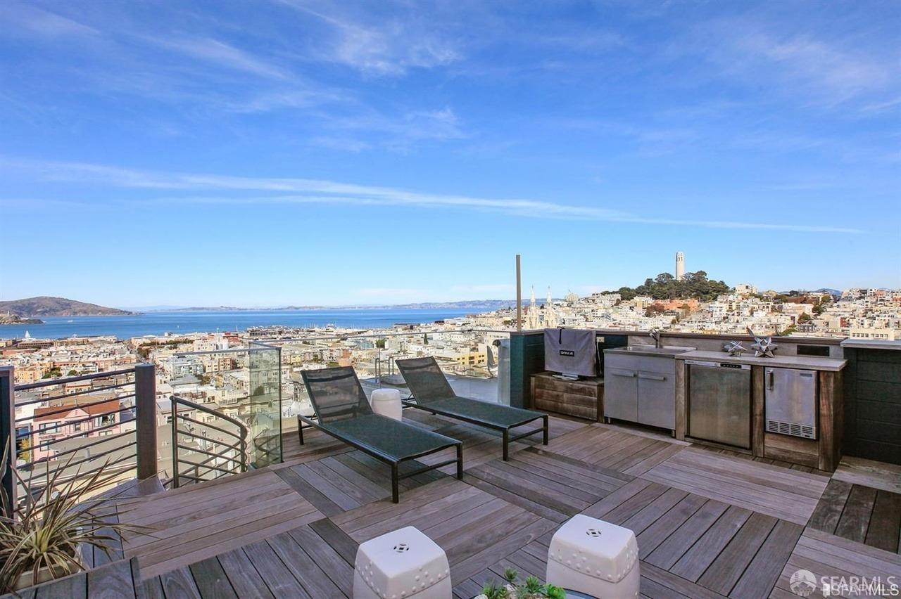 a view of roof deck with seating space and a ocean view