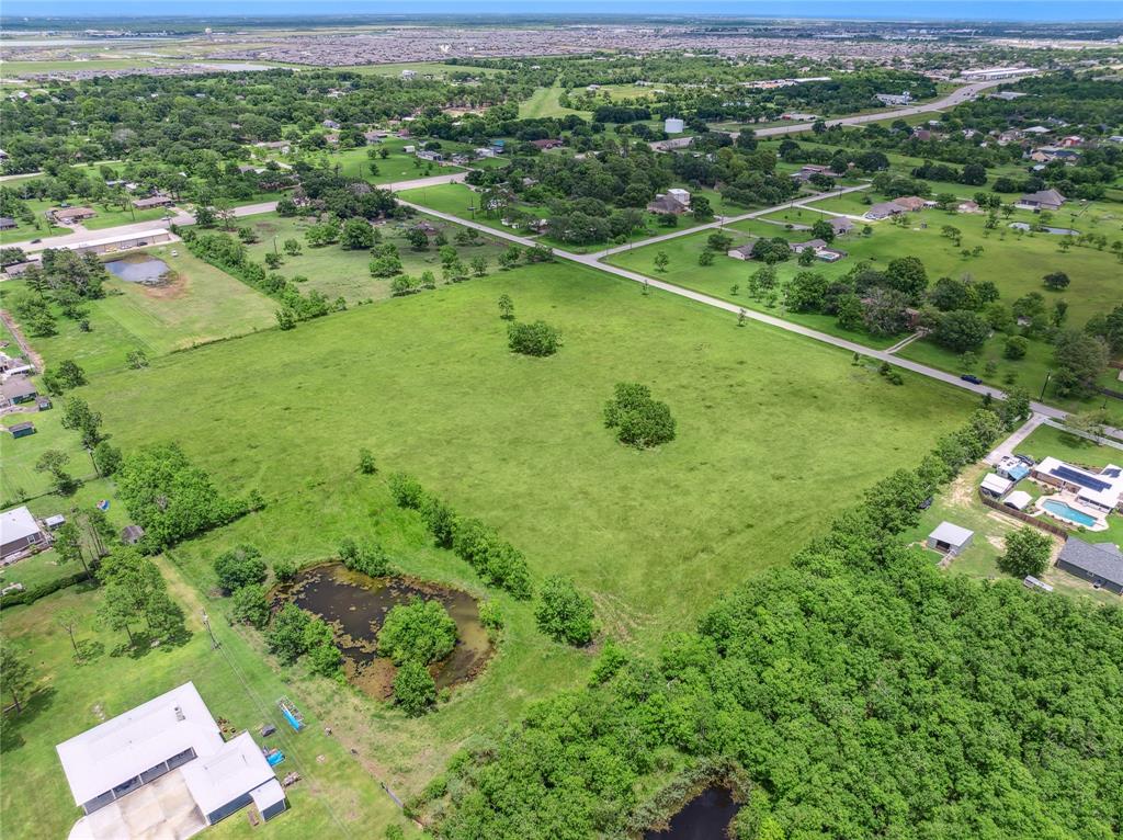 a view of a lush green field with a houses in the background