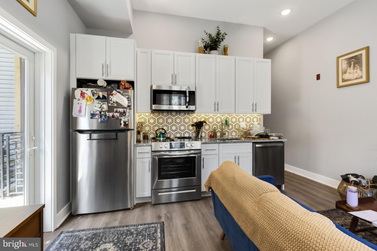 a kitchen with stainless steel appliances granite countertop a refrigerator stove and sink