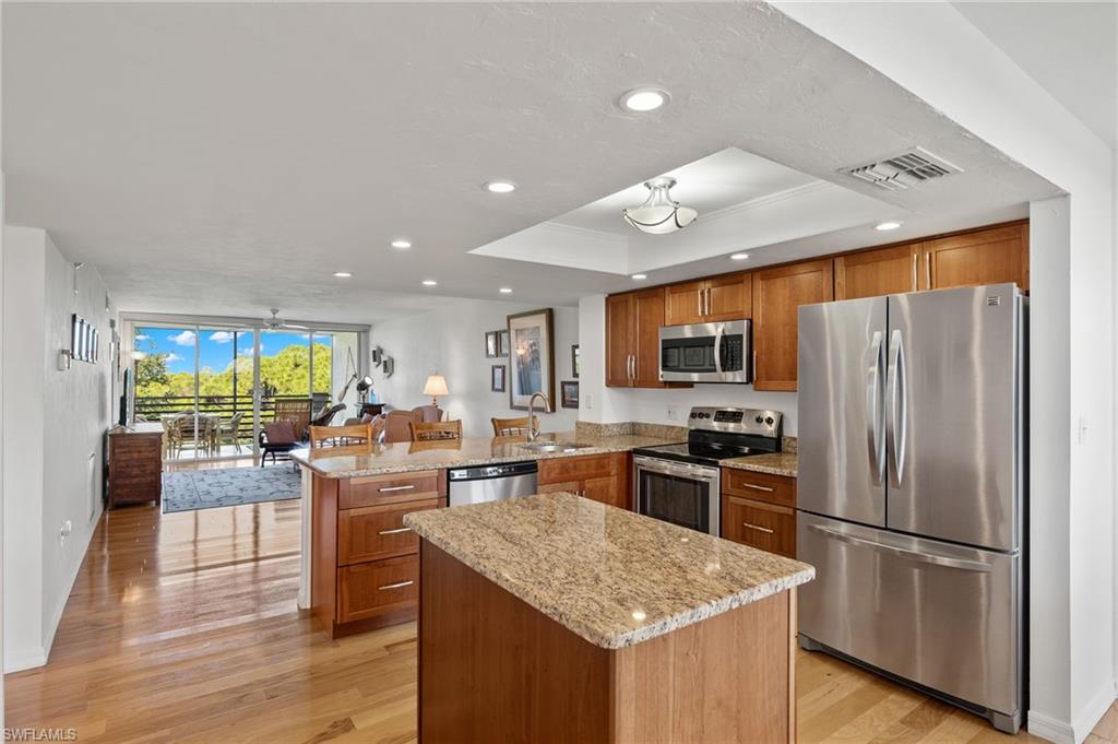 a kitchen with stainless steel appliances granite countertop a refrigerator stove microwave and cabinets