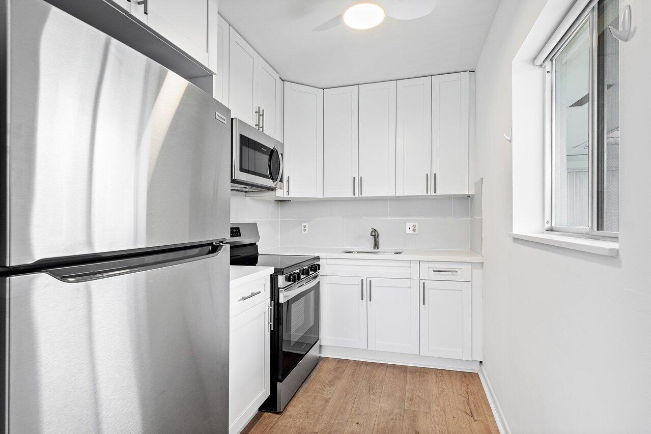 a kitchen with stainless steel appliances a refrigerator sink and microwave