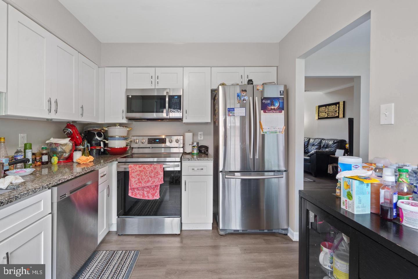 a kitchen with refrigerator cabinets and wooden floor