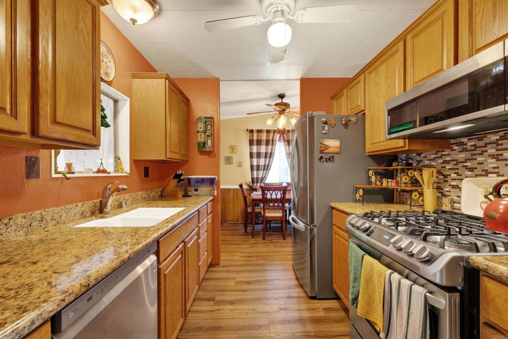 a kitchen with stainless steel appliances granite countertop a sink stove and refrigerator