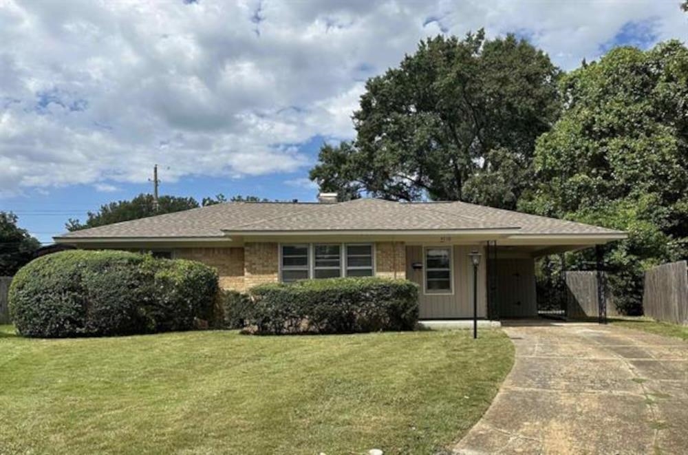 Ranch-style house featuring a front yard and a carport