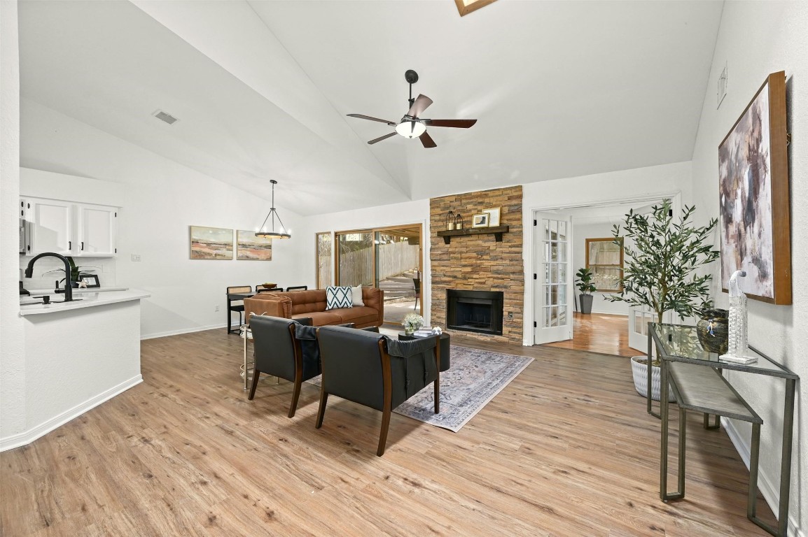 a living room with furniture a fireplace and wooden floor