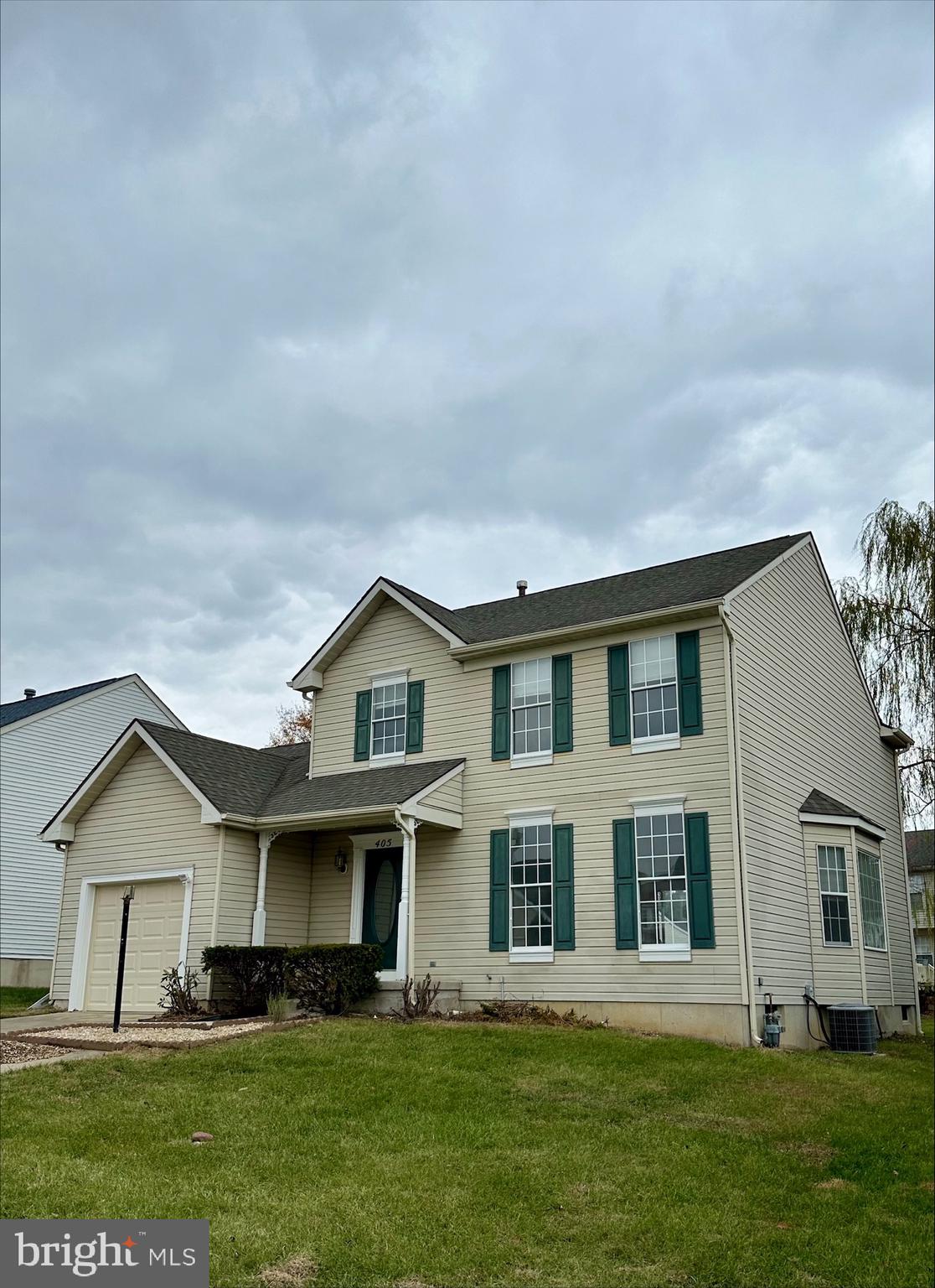 a front view of a house with a garden and yard