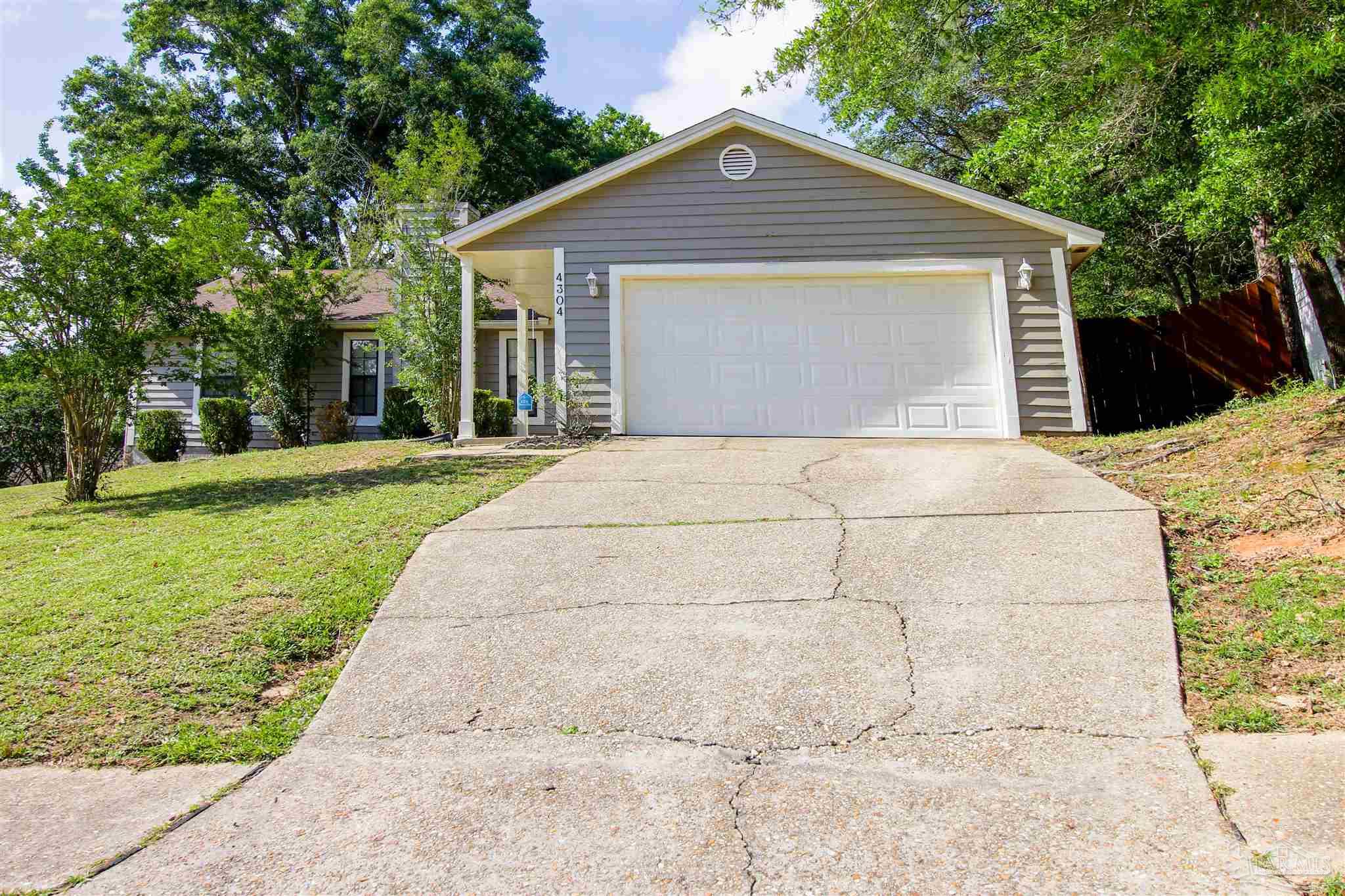 a front view of a house with a yard and trees