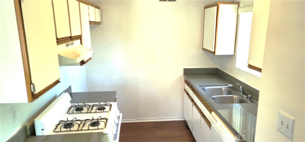 a kitchen with a sink a stove and a window