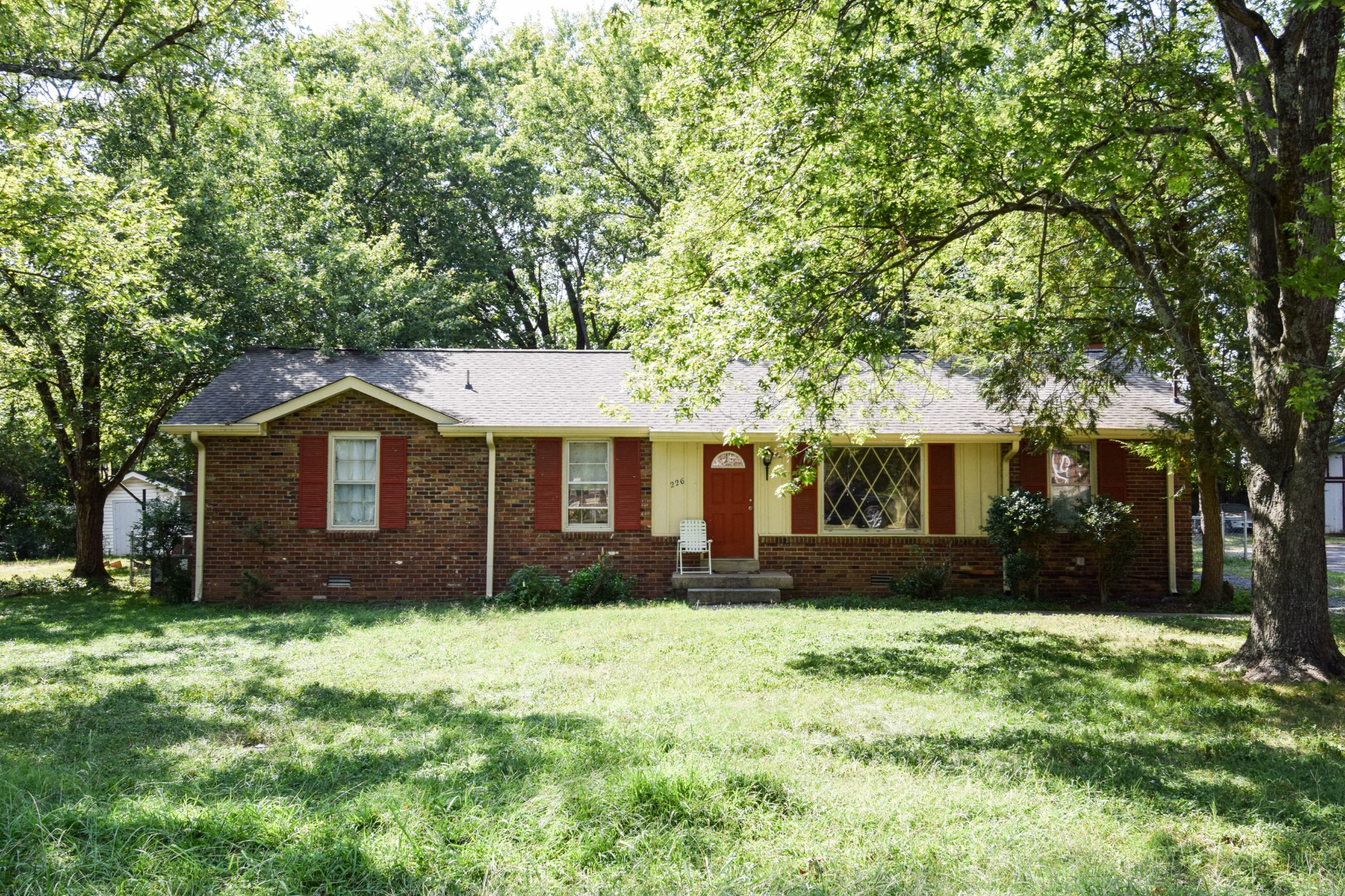 a front view of a house with a yard and trees