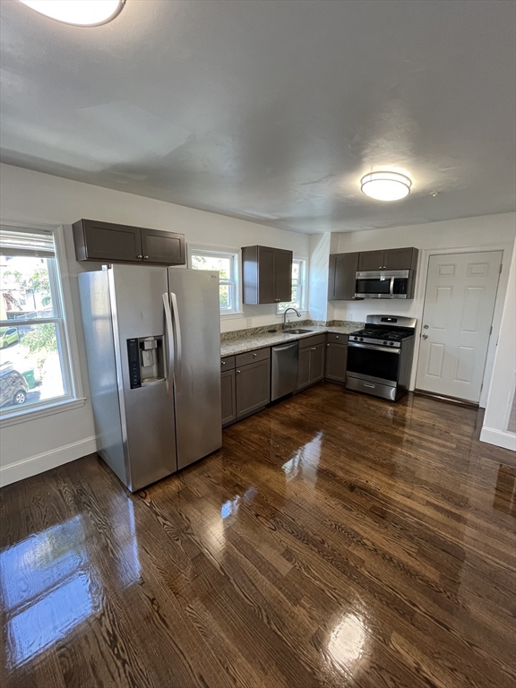 a kitchen with stainless steel appliances granite countertop a refrigerator and a stove