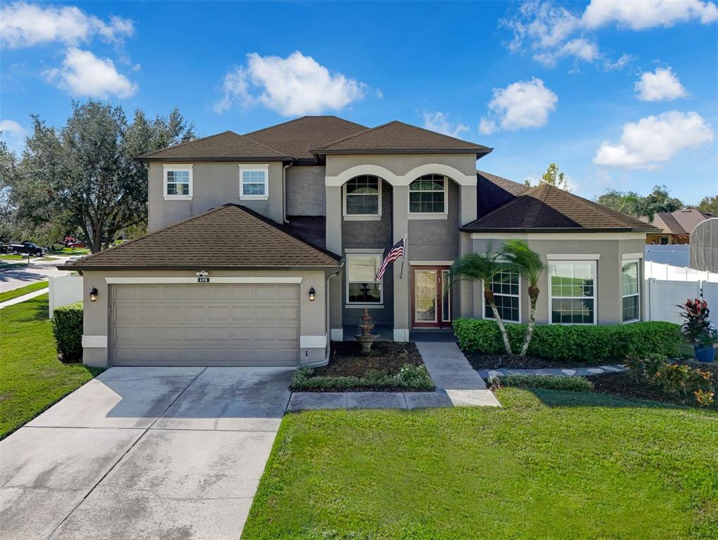 a front view of a house with a yard and garage