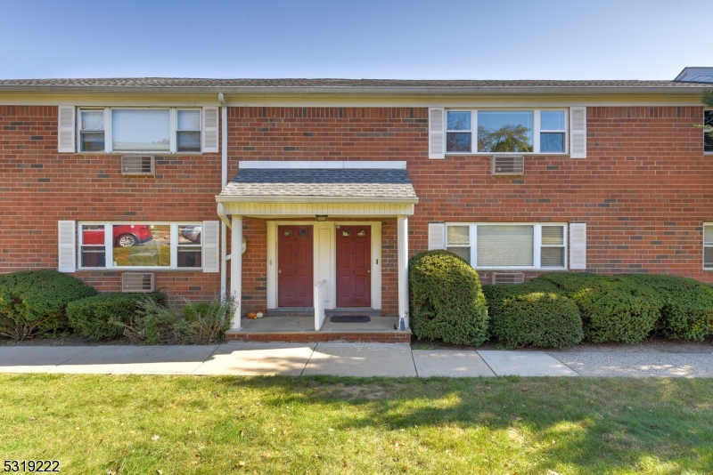 front view of a brick house with a yard