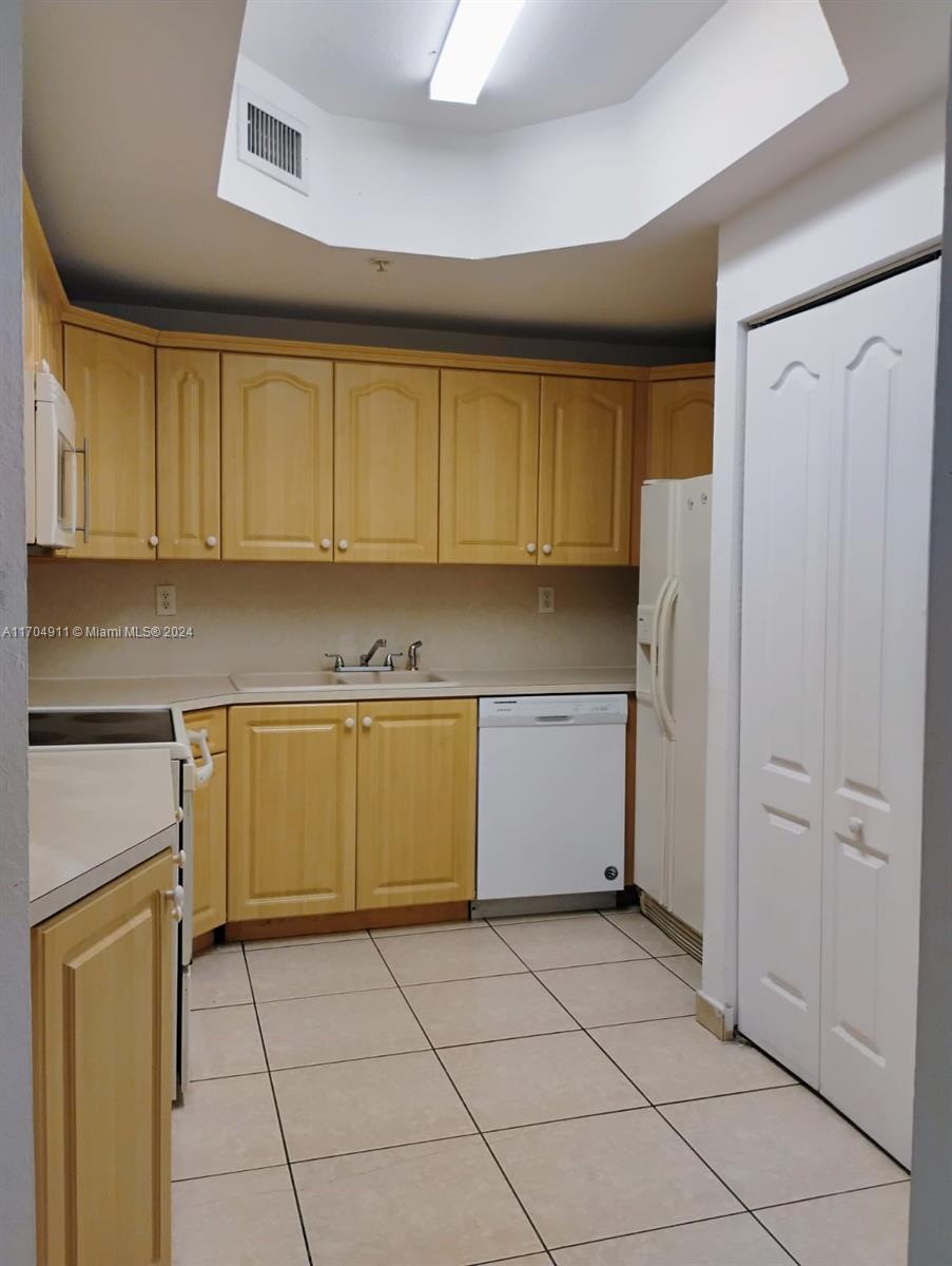 a kitchen with a refrigerator sink and cabinets