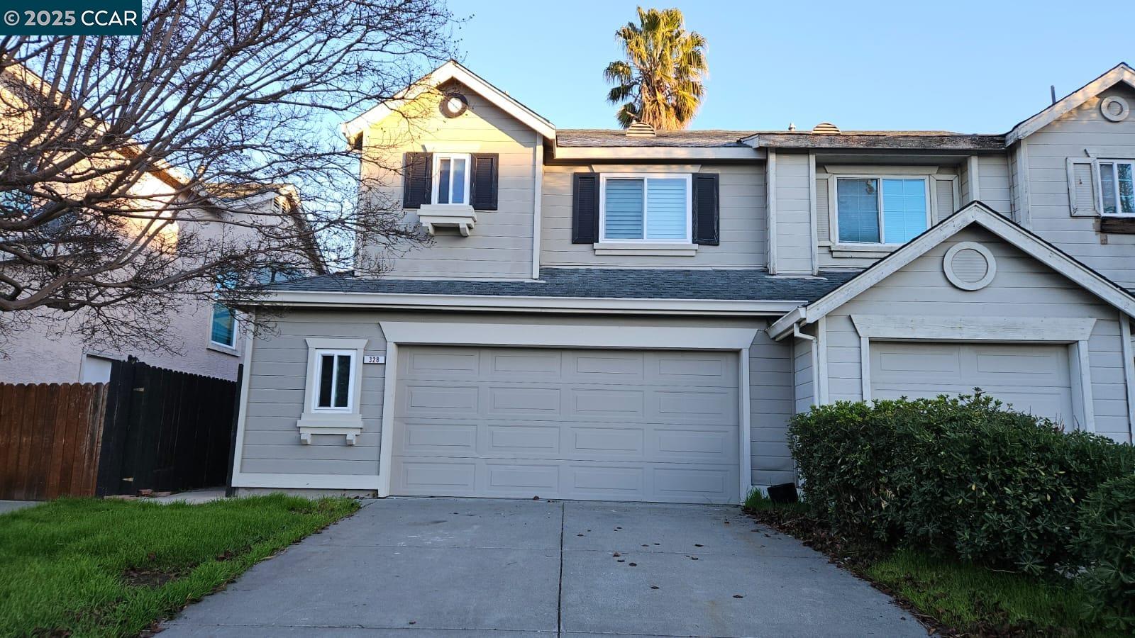 a front view of house with yard and trees in the background